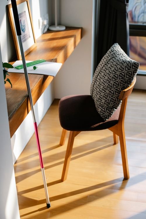 A wooden desk and chair in a bright room. Exact location is not confirmed.